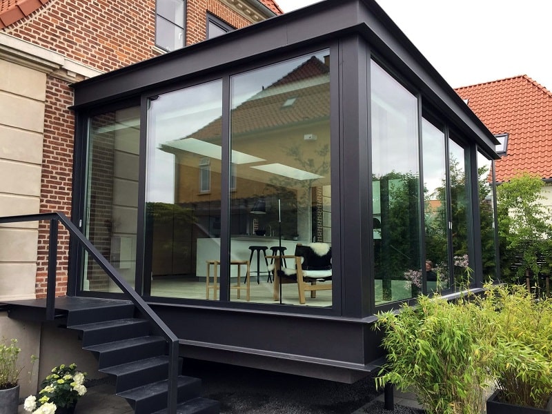 Skræddersyede alu- og glaspartier til udestue. Sorte alu-profiler fra Schüco m. skydedøre. njpglas.dk